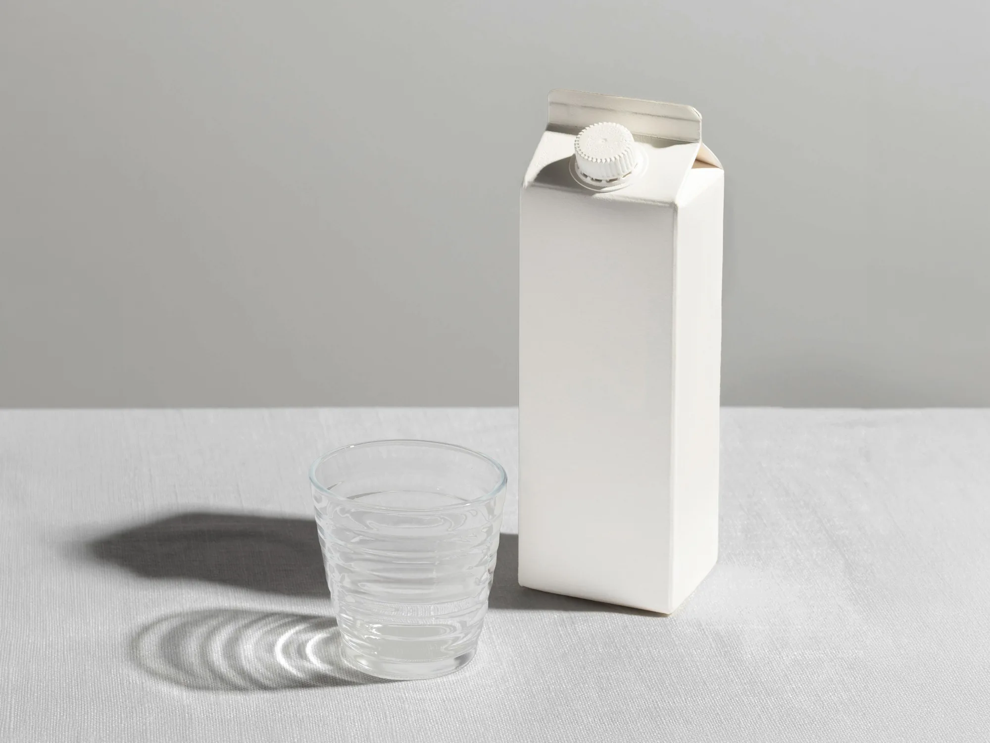 A blank carton beside a glass of water